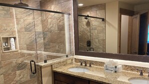 A bathroom with two sinks, a shower, and a large mirror. - Cozy 1-bedroom condo with balcony in beautiful Gatlinburg with Water Park passes (Gatlinburg)