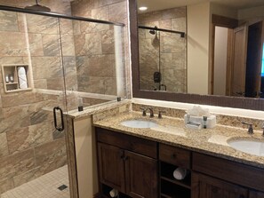 A bathroom with two sinks, a shower, and a large mirror. - Cozy 1-bedroom condo with balcony in beautiful Gatlinburg with Water Park passes (Gatlinburg)