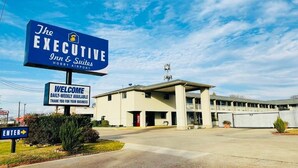 Letrero de hotel que muestra 'The Executive Inn & Suites' y un mensaje de bienvenida.