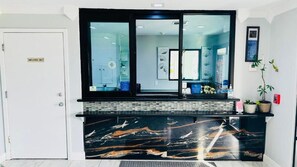 A reception area with a marble counter, a door labeled 'Employees Only,' and a potted plant.