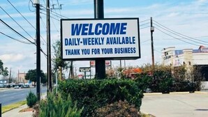 Un letrero de hotel con el nombre 'The Executive Inn & Suites' y un mensaje de bienvenida.