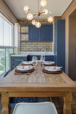 A dining table set for four with a modern chandelier above. - StayHome - Campo Belo - Gym & Pool (São Paulo)