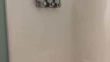 A white shower enclosure with a control panel and a single lever.
