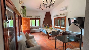 A dining area with a table, chairs, and a television.