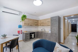 Eine moderne Küche mit Holzschränken, einem eingebauten Backofen und einem grauen Kühlschrank.