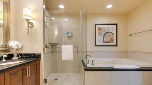 Un baño moderno con ducha envuelta en vidrio, una bañera amplia y un lavamanos con espejo y lavabo.