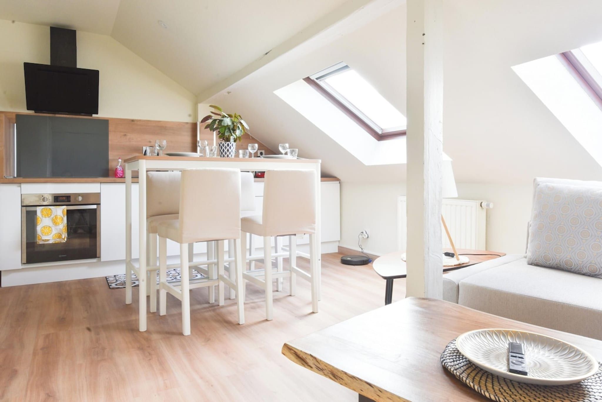 Een modern loft-appartement met een eethoek, kitchenette en een gezellige zithoek met een bank.