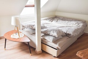 A bedroom with a loft bed, a bedside table with a lamp, and a view of the sky through a window. - Mulhouse's Golden Age (Mulhouse)