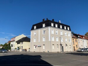 A multi-story building with a flat roof, large windows, and a street in front. - Apogee Mulhousienne - Cozy attic apartment, AC, Wi-Fi (Mulhouse)