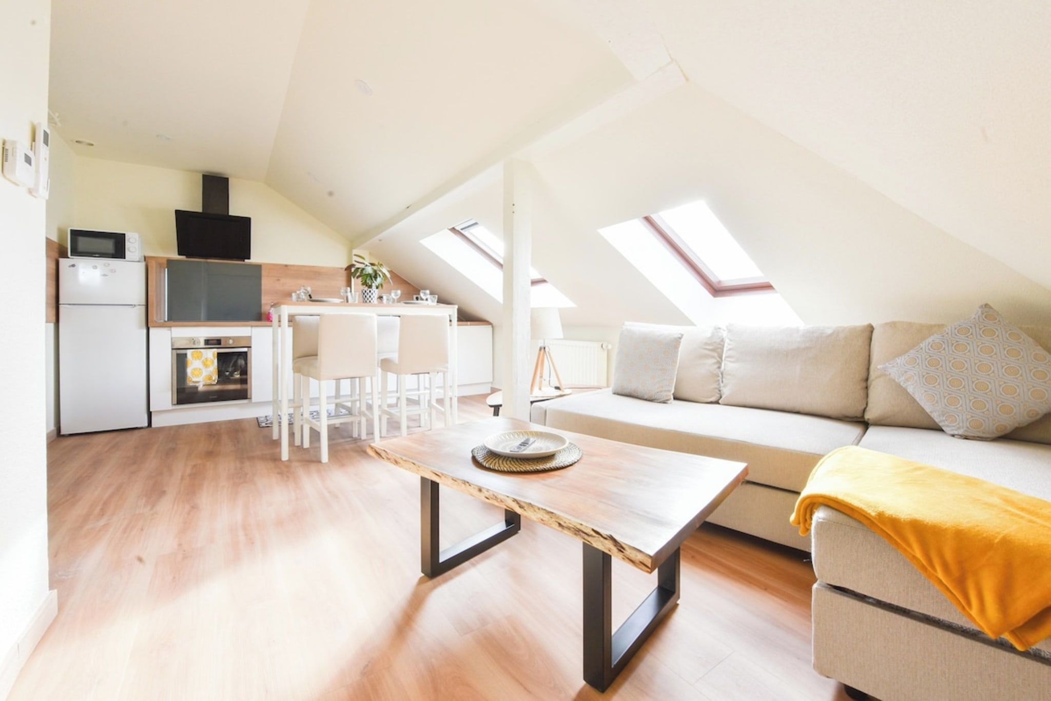 Un appartement moderne de style « loft », doté d’une cuisine ouverte, d’un espace repas et d’un salon.