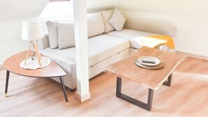 Ett modernt vardagsrum med en soffa, ett soffbord och en lampa.