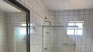 A bathroom with a shower, toilet, sink, and bathtub.