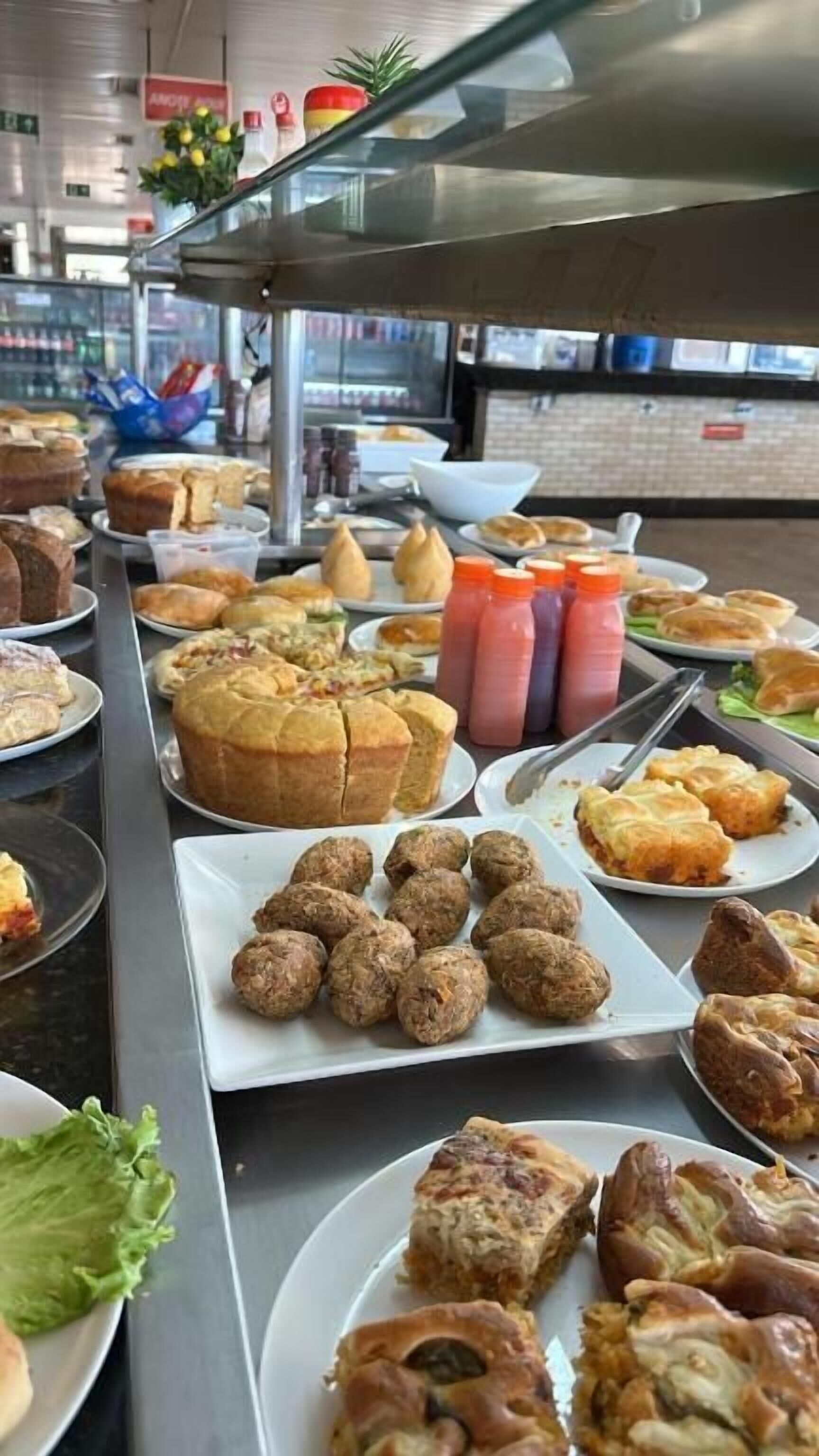 A buffet with various food items including pastries, meatballs, and salads.