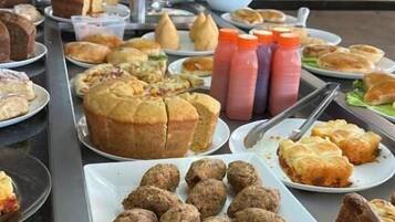 A buffet with various food items including pastries, meatballs, and salads.