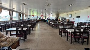 A spacious indoor dining area with multiple tables and chairs arranged in rows.