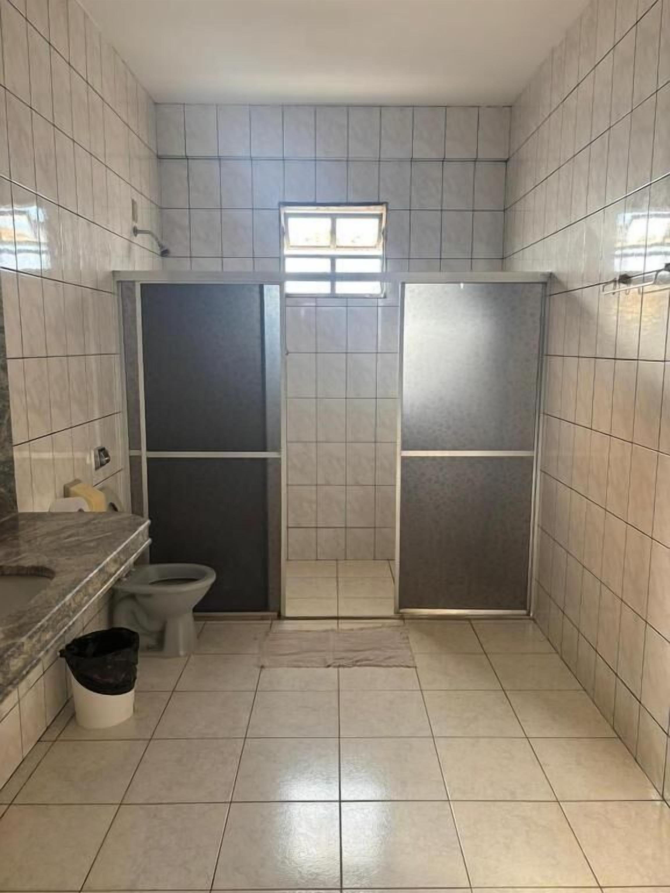 Un baño pequeño con inodoro, lavamanos y cabina de ducha.