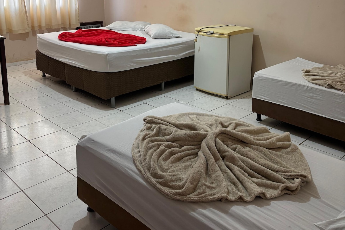 Habitación de hotel con dos camas, un calentador y una ventana con cortinas.