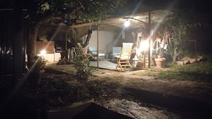 An outdoor patio area with a table and chairs, surrounded by potted plants and a wooden structure providing shade. - L'Instant Sud in Châteauneuf-de-Grasse (Châteauneuf-Grasse)