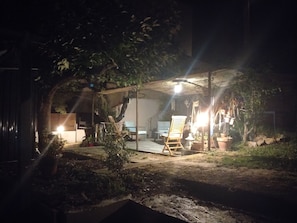 An outdoor patio area with a table and chairs, surrounded by potted plants and a wooden structure providing shade. - L'Instant Sud in Châteauneuf-de-Grasse (Châteauneuf-Grasse)