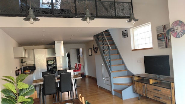 A modern interior with a dining area, kitchen, staircase, and a large window. - L'Instant Sud in Châteauneuf-de-Grasse (Châteauneuf-Grasse)