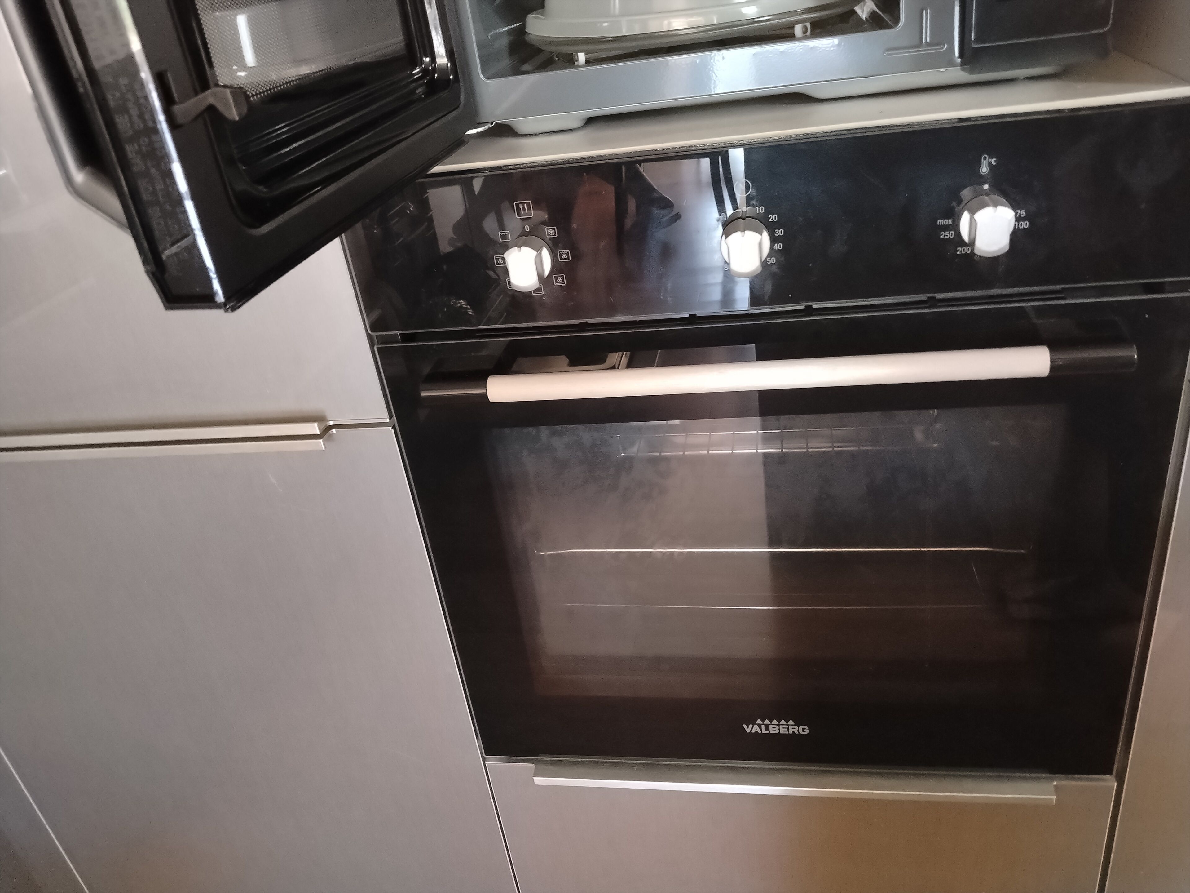 Ein schwarzer Backofen mit Bedienfeld und einer weißen Tür.