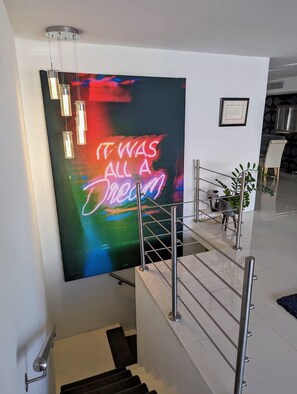 En trappa med en neonskylt som visar texten ”DET VAR BARA EN DRÖM” och ett inramat citat på väggen.