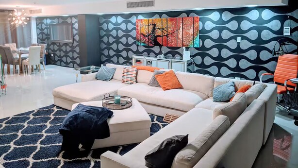 A modern living room with a sectional sofa, a dining area with chairs, and a large abstract painting on the wall. - ★Luxury Beachfront Oasis ~ Ocean Views ~ ♛King Bed (San Juan)