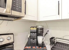 Une petite cuisine équipée d’une machine à café, d’une bouilloire et d’un grille-pain.