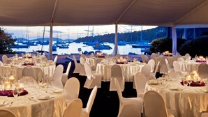 An outdoor dining area with tables set for a formal event, overlooking a marina with boats. - 2BR Resort View Villa at Westin St. John Resort Villas (Cruz Bay)