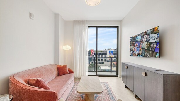 A modern living room with a sofa, a coffee table, and a cabinet. - Chic Miami Apt Pool Gym & Sleeps 4 (Miami)