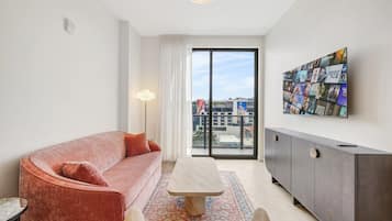 Un salon moderne avec un canapé, une table basse et un meuble.