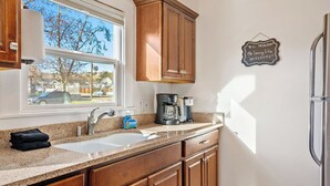 A kitchen with a window, a coffee maker, and a sign on the wall. - Paso on Oak by Avantstay Cottage-style Home + Full Kitchen + Front Deck Near Downtown (Paso Robles)