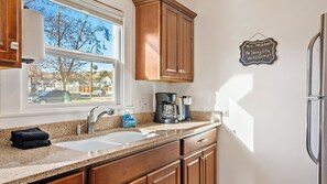 A kitchen with a window, a coffee maker, and a sign on the wall. - Paso on Oak by Avantstay Cottage-style Home + Full Kitchen + Front Deck Near Downtown (Paso Robles)