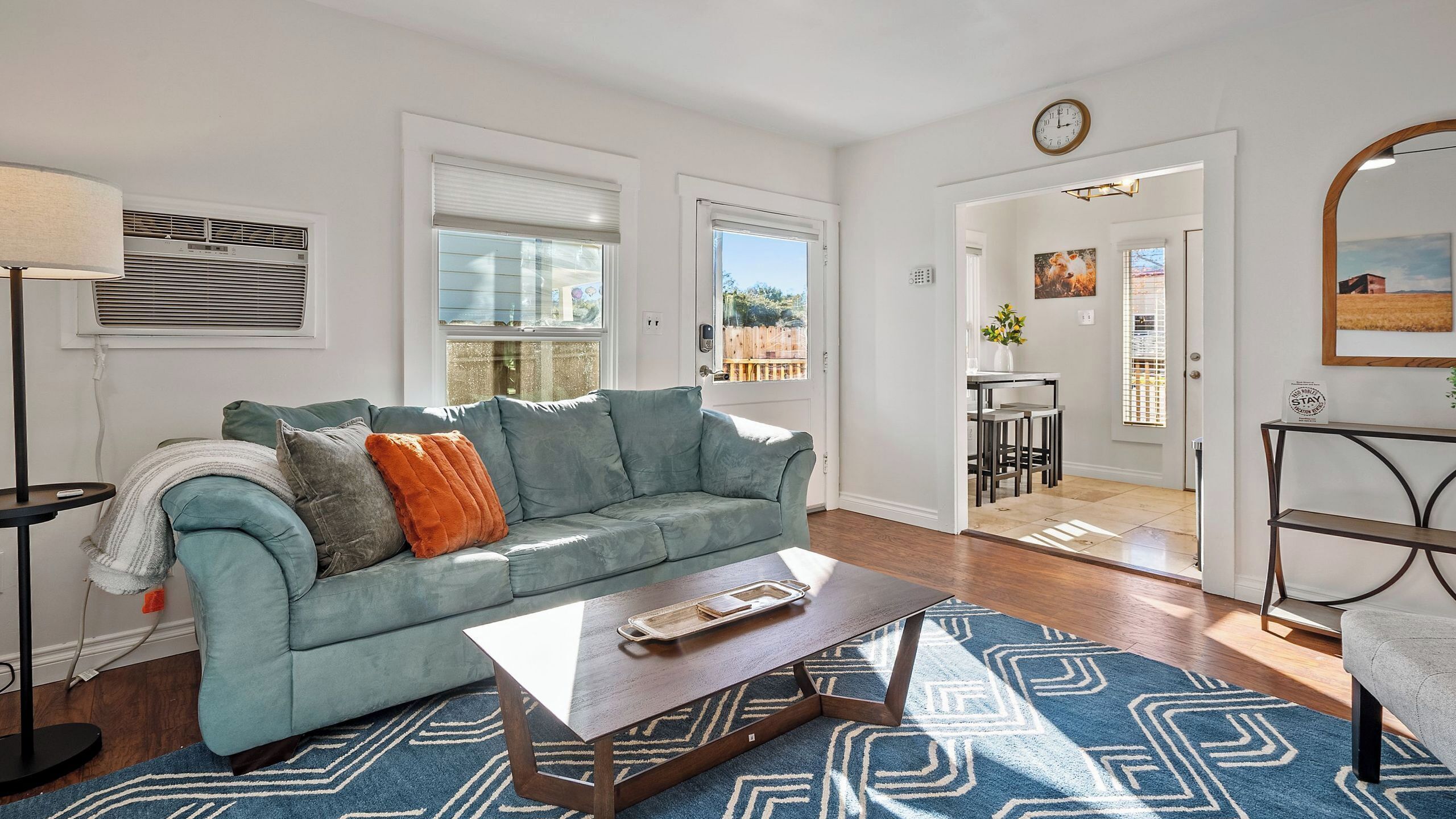 A living room with a sofa, coffee table, and patterned rug.