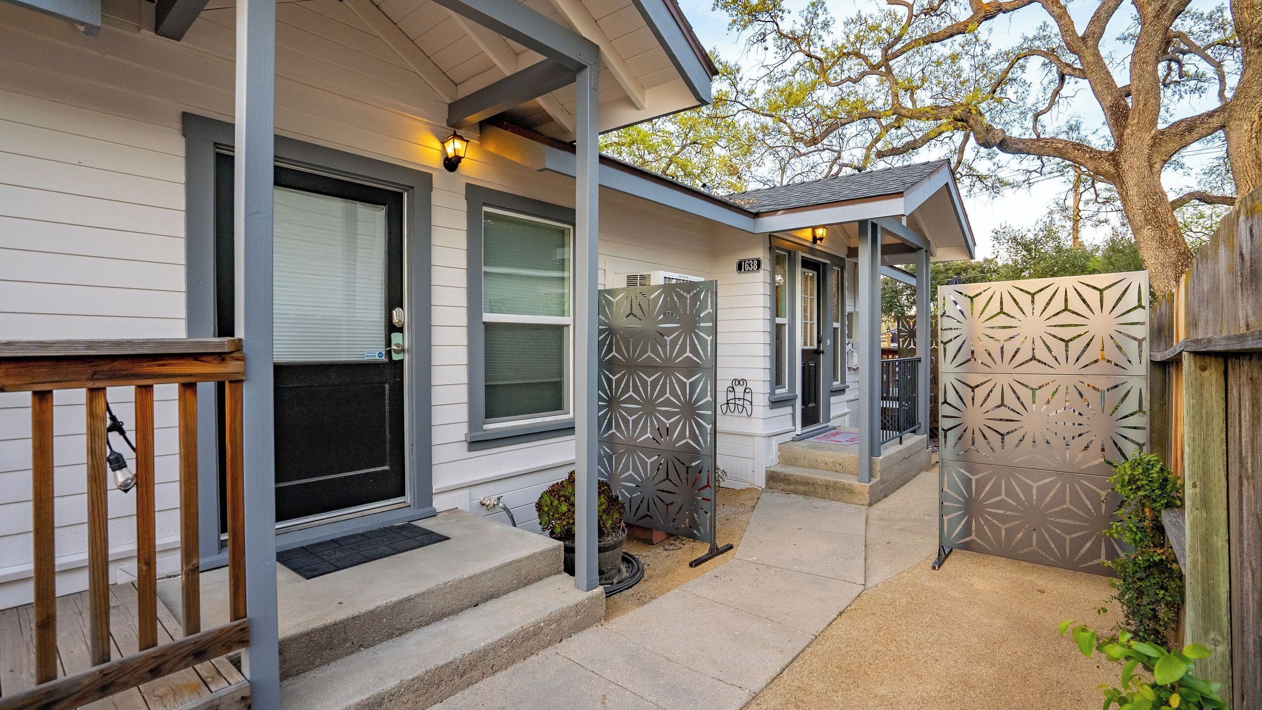 A house with a covered porch, a mailbox, and a decorative metal fence.