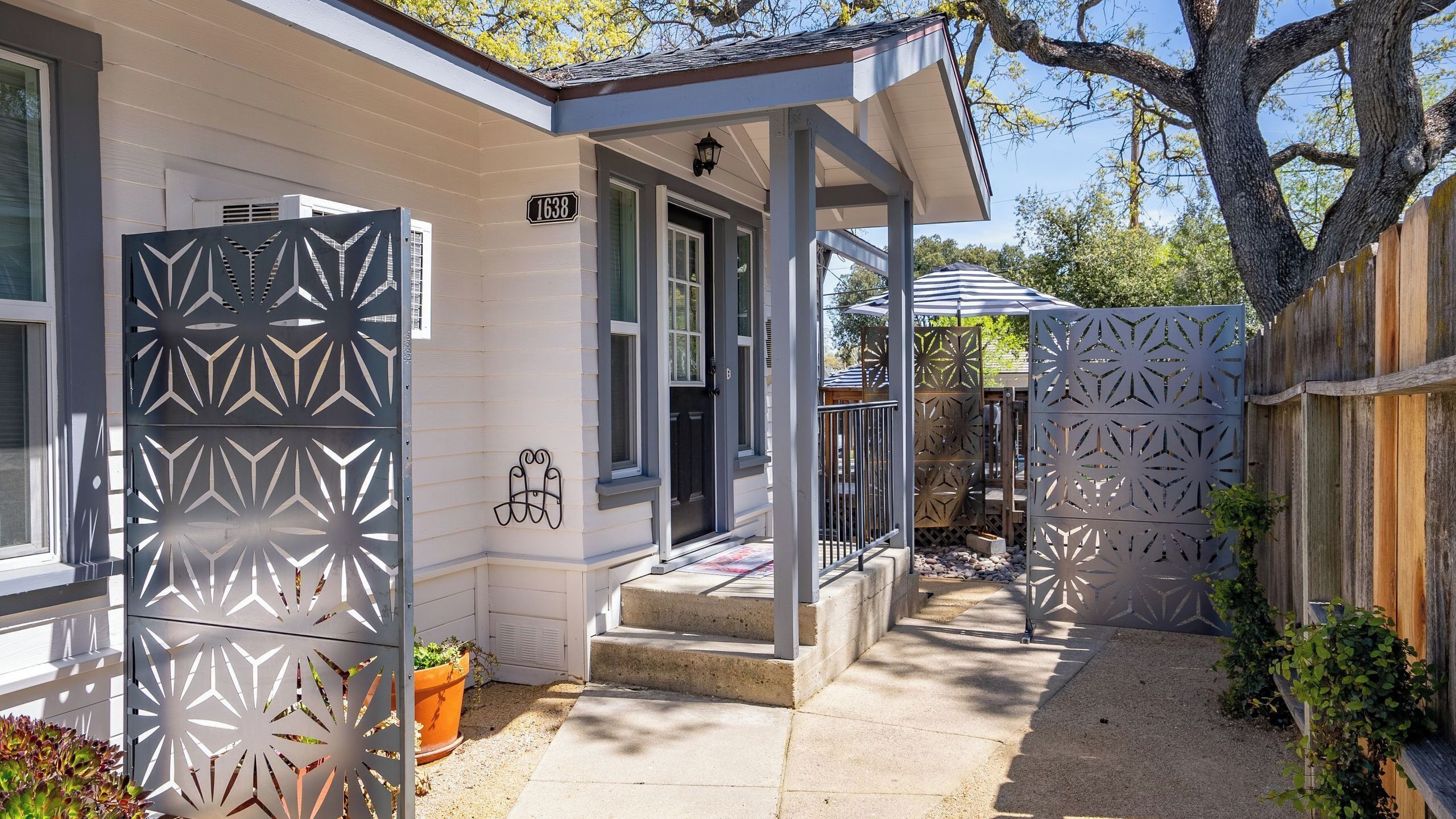 A residential property with a covered porch, a gated entrance, and a visible house number.