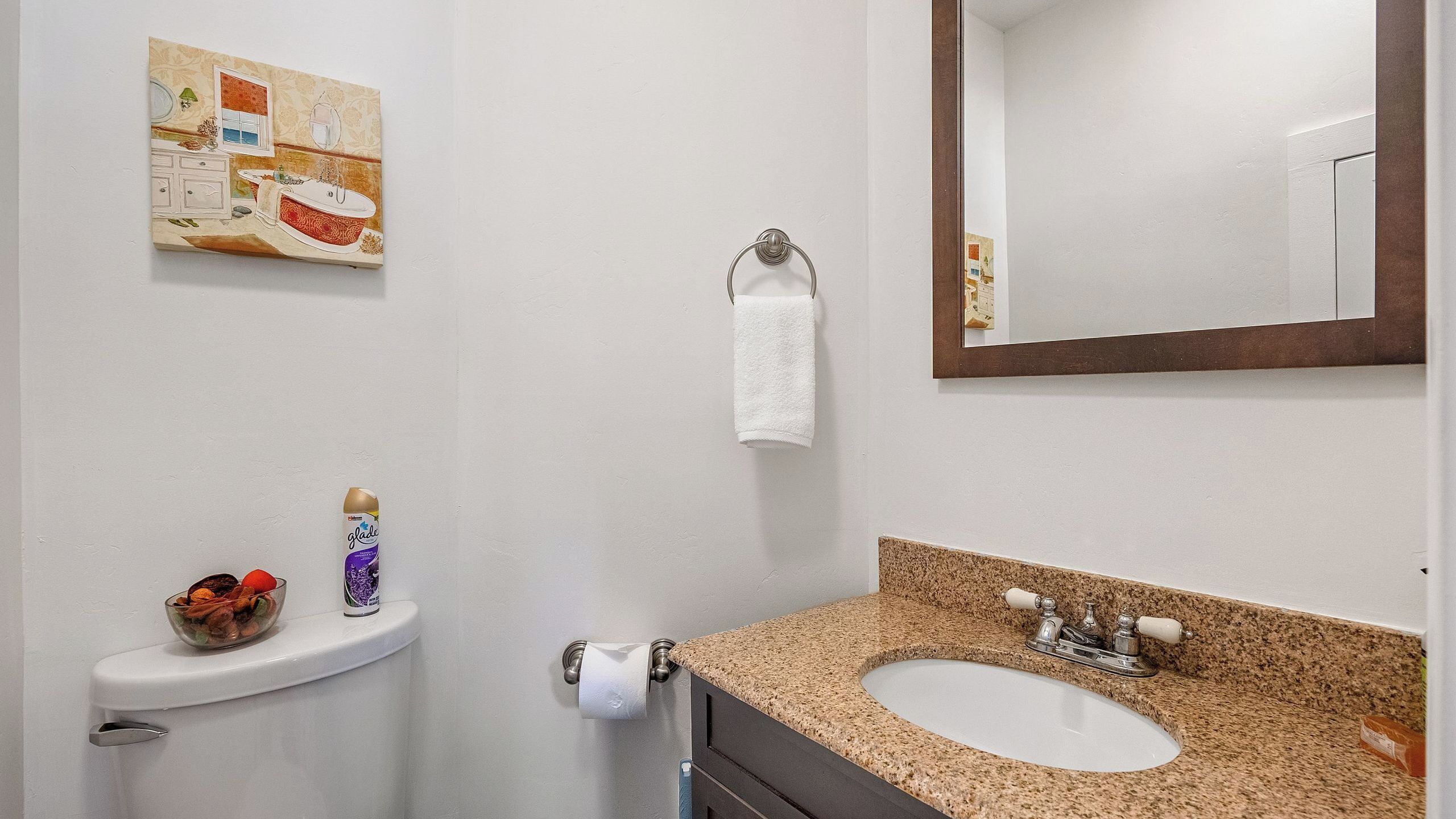 Un baño con lavamanos, inodoro y espejo.