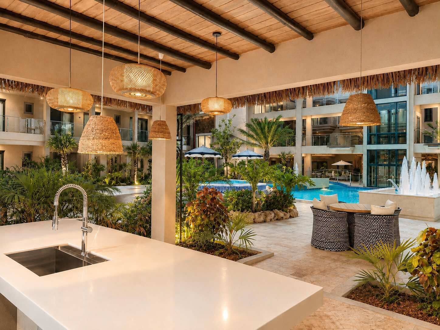 A hotel lobby with a pool, outdoor seating, and hanging wicker lamps.