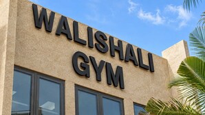 Un edificio con el letrero 'WALISHALI GYM', que indica una instalación de gimnasio.
