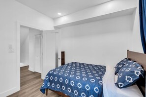 Ein Schlafzimmer mit Bett, Tür und Lichtschalter.