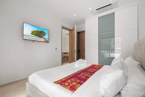A modern bedroom with a large bed, a flat-screen TV, and a glass partition wall. - 5-Min Drive to Eagle Beach|Large Patio|Pool&Jacuzzi (Noord)