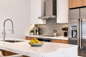 A modern kitchen with a stainless steel refrigerator, a coffee maker, and a kettle on the counter. - 5-Min Drive to Eagle Beach|Large Patio|Pool&Jacuzzi (Noord)