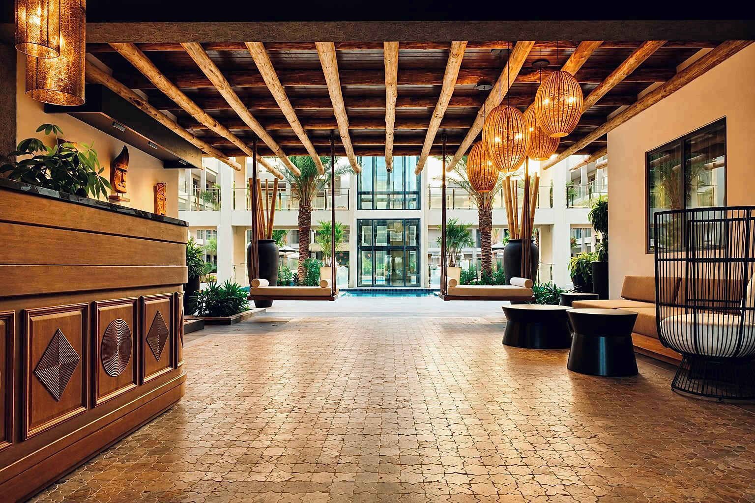 A spacious lobby with a brick floor, wooden ceiling beams, and hanging spherical light fixtures.