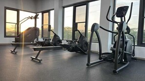 A gym with cardio machines and weight equipment, large windows, and a concrete floor. - Top-Floor 1BR | Resort Pool | Close to Eagle Beach (Noord)