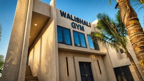 Un bâtiment dont la façade porte une enseigne indiquant « Walishali Gym ».