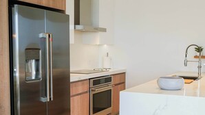 A modern kitchen with stainless steel appliances, wooden cabinets, and a marble countertop. - Top-Floor 1BR | Close to Aruba’s Best Beaches (Noord)