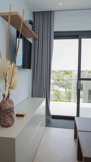 Ein modernes Wohnzimmer mit einem weißen Konsolentisch, einer dekorativen Vase und Blick auf einen Balkon mit Geländer.