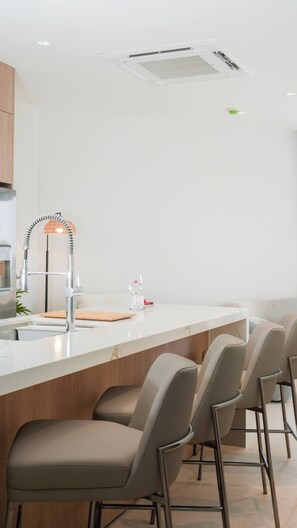 A modern kitchen with a central island, bar stools, and a pendant light. - Top-Floor 1BR | Close to Aruba’s Best Beaches (Noord)