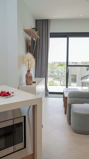 Ein modernes Wohnzimmer mit Essbereich, einer Couch, einem Tisch und Blick ins Freie.