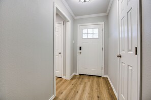 A hallway with white doors and a wooden floor. - Riverside Retreat 3BDRM/2BA (San Angelo)